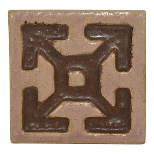 May include: A square ceramic tile with a brown geometric design on a light purple background.