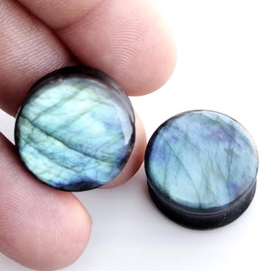 May include: Pair of round, blue and green labradorite stone ear gauges. The gauges are smooth and have a polished finish.