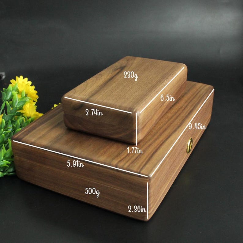 May include: Two wooden boxes, one stacked on top of the other. The top box is 3.74in x 6.5in x 1.77in and weighs 230g. The bottom box is 5.91in x 9.45in x 2.36in and weighs 500g. Both are made of a dark wood.