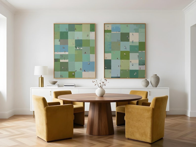 May include: Two large rectangular wall art pieces featuring a grid of green, blue, and beige squares with small figures, displayed above a round wooden dining table with four mustard yellow upholstered chairs in a bright room.