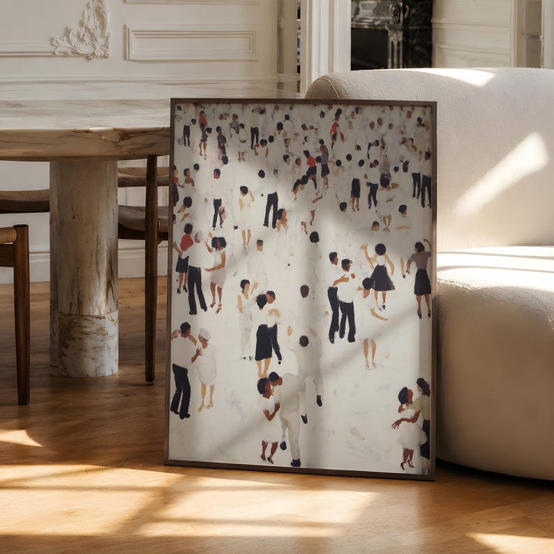 Large unframed print leaning by dining table, sunlight on neutral abstract with tiny people dancing print