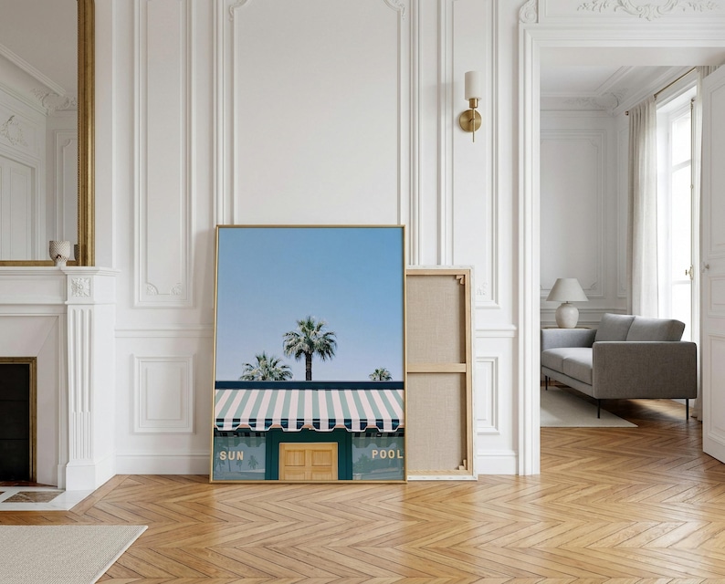 May include: A rectangular wall art print featuring a clear blue sky above palm trees and a building with a green facade, a striped awning, and a central wooden door. The text SUN and POOL is printed in white on the green wall sections.