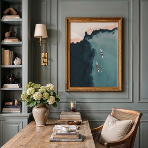 Framed vintage lake print in elegant study, muted blush shoreline and tiny boats, coastal wall art