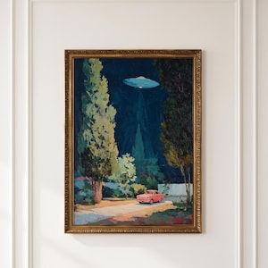 May include: A framed painting depicting a pink car parked on a road at night, surrounded by tall dark trees. Above the car, a glowing blue disc-shaped object hovers in the dark sky, casting a beam of light downward toward the vehicle.