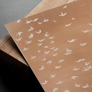a close-up view of a wooden surface with a repeating pattern of white birds.