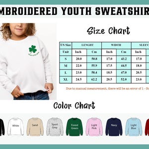 May include: White embroidered youth sweatshirt with a green shamrock and the text "Lucky Little One." The image includes a size chart with measurements in inches and centimeters, and a color chart with options like black, white, and maroon.