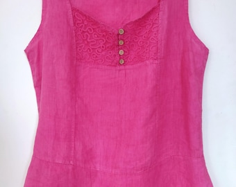 May include: A vibrant fuchsia pink linen top, sleeveless with a square neckline. It features an embroidered panel with four small, round buttons. The top has a gently flared hem and is displayed on a white hanger. The fabric appears lightweight.