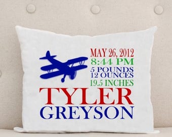 May include: White pillow with blue airplane graphic, red and blue text "TYLER GREyson", and birth details: May 26, 2012, 8:44 PM, 5 pounds 12 ounces, 19.5 inches.