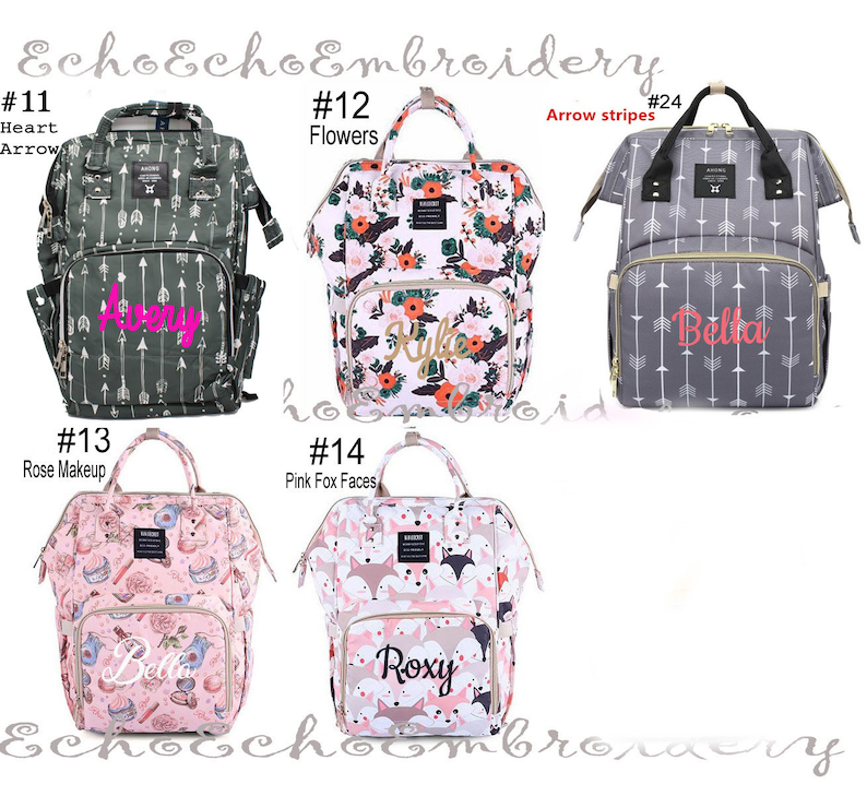 May include: Ten different diaper bags with various patterns and colors. The bags have a zippered front pocket and a large main compartment. The bags are personalized with names like Avery, Bella, Kyle, and Roxy. The bags are numbered 11 through 14 and 24.