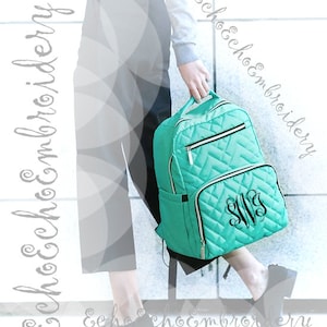 May include: A turquoise quilted backpack with a zippered front pocket and a monogrammed design. The backpack has adjustable straps and a top handle.