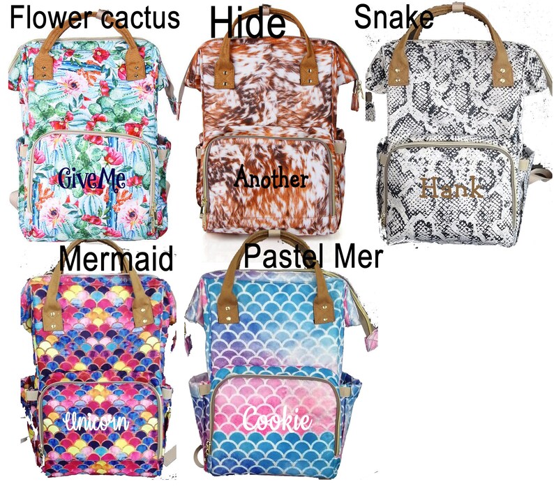 May include: Six different patterned diaper bags with personalized embroidery. The bags are all black with brown leather accents. The patterns include a floral cactus print, a cowhide print, a snake print, a mermaid print, a pastel mermaid print, and a unicorn print. The embroidery includes the words "Give Me", "Another", "Hank", "Unicorn", and "Cookie".