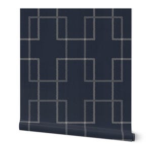 May include: A roll of navy blue wallpaper with a geometric pattern of interlocking light gray rectangles. The design is repeated across the surface, creating a modern and textured look. The wallpaper is rolled up, showing the edge.