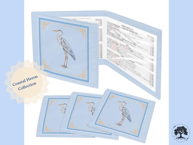 May include: A light blue Coastal Heron Collection set featuring a wallet and coasters. The wallet is open, revealing printed pages. Each item has a heron illustration within a decorative border. The set is on a light blue background.