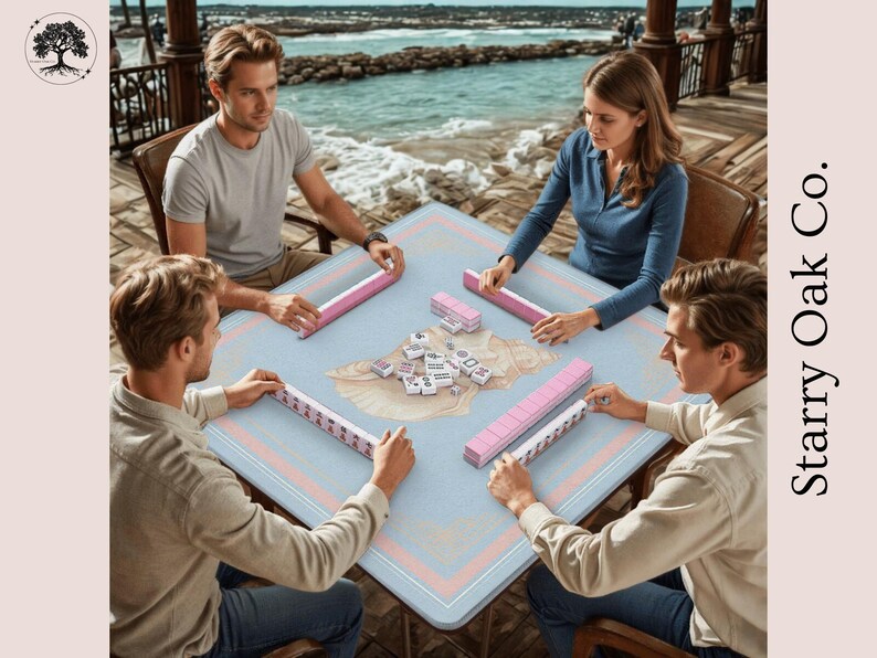 May include: Four people playing mahjong on a light blue table with pink and peach trim. The table is set with tiles and pink tile racks. The game is being played outdoors with a view of the ocean.