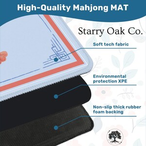 May include: A close-up of a high-quality Mahjong mat with a light blue surface and a red and orange border. The mat has a soft tech fabric, environmental protection XPE, and a non-slip thick rubber foam backing. The text "High-Quality Mahjong MAT" and "Starry Oak Co." are visible.