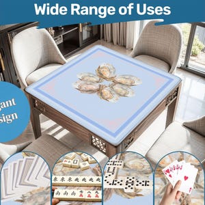 May include: A square wooden table with a light blue top featuring an oyster design. The table is surrounded by chairs and is shown with playing cards, dominoes, and mahjong tiles, suggesting a variety of uses. The text "Elegant Design" is visible.
