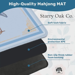 May include: A close-up of a high-quality Mahjong mat with a light blue surface featuring a bird graphic and gold accents. The mat has a soft tech fabric, environmental protection XPE, and a non-slip thick rubber foam backing. The text "Starry Oak Co." is also visible.