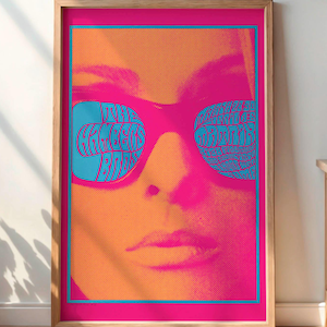 May include: A framed poster with a vibrant, retro design. The artwork features a close-up of a face wearing sunglasses with the text "THE GRACEFUL BADDIES" in the lenses. The color palette includes pink, orange, and blue.