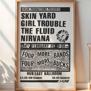 May include: A framed black and white concert poster for Skin Yard, Girl Trouble, The Fluid, and Nirvana, with the date February 25th. The poster is displayed in a room with a wooden cabinet, a lamp, and a potted plant.
