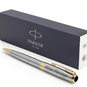 May include: A silver Parker pen with gold accents and the engraved text "Your Message" next to a navy blue box with the Parker logo and text.