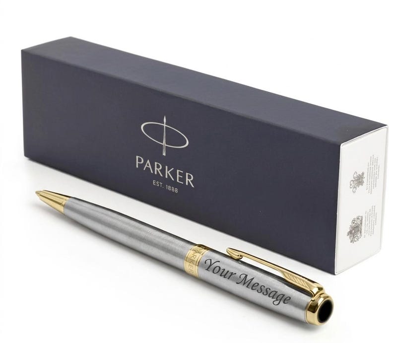 May include: A silver Parker pen with gold accents and the engraved text "Your Message" next to a navy blue box with the Parker logo and text.
