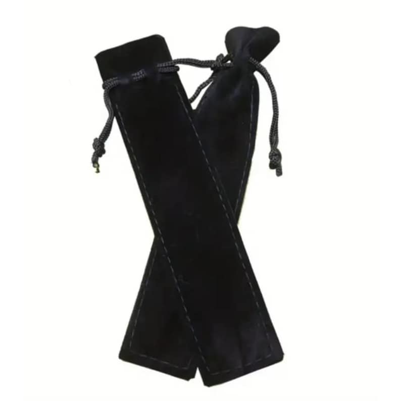 May include: Two black velvet pen pouches with drawstring closures. The pouches are rectangular with a stitched seam down the center. The drawstrings are black and knotted at the ends. The pouches are displayed against a white background.