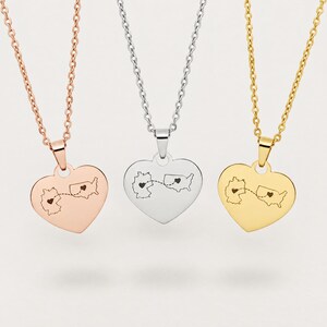 May include: Three heart-shaped pendants on delicate chains in rose gold, silver, and gold tones. Each pendant features an engraved map of Germany and the United States connected by a dashed line with a small heart on each country's landmass.