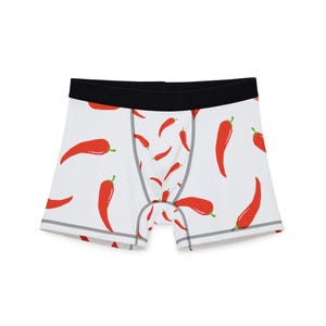 May include: White boxer briefs with a black waistband and a pattern of red chili peppers. The underwear has a classic boxer brief cut with a comfortable fit. The chili pepper design adds a playful touch to the garment.