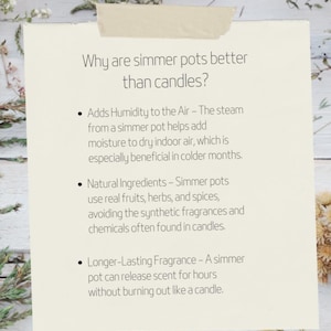 May include: A white card with black text explaining why simmer pots are better than candles. The text lists three reasons: adds humidity to the air, uses natural ingredients, and has a longer-lasting fragrance. The card is on a white wooden surface with dried flowers.