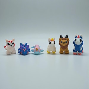 May include: A white ceramic mug with a black handle and the text "But First, Coffee" in a black, handwritten-style font. The mug is on a white surface.