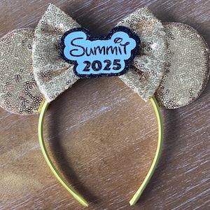 Pode incluir: Faixa de cabeça de orelhas de Minnie Mouse com lantejoulas douradas, com um laço de feltro preto e branco e uma etiqueta de feltro branco que diz "Summit 2025".