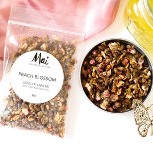 Peut inclure: Un sachet en plastique transparent rempli de fleurs de pêcher séchées. Le sachet porte une étiquette blanche avec le texte "Mai DreamerGallery.com Peach Blossom Dried Flowers 100% Pure and Natural"