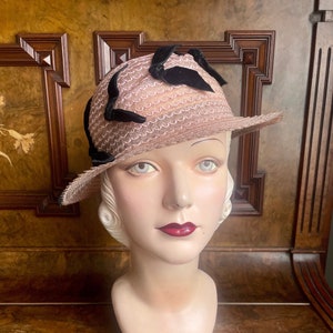 Fantastische roze doorschijnende strohoed uit de jaren 1930 met zwart fluwelen strikken. Maat: 21,5" en 55 cm (damessmall) New Old Stock