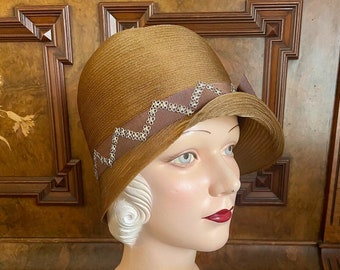 1920s golden-brown translucent straw cloche with metal embellishment. New Old Stock, 21" small