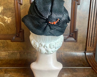 Early 1930s glossy black draped ‘straw’ cap with coral ornament. Size 21 to 22 small to medium