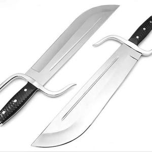 May include: Two large, shiny, silver-colored swords with black handles and curved handguards. The blades are wide and flat, with a sharp edge. The handles have a textured grip. The swords are displayed against a white background.