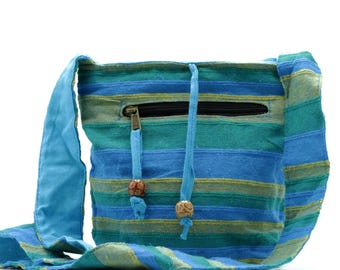 May include: A blue and green striped crossbody bag with a long strap. The bag has a zipper closure and two wooden beads on the drawstrings. The bag is made of a woven fabric.