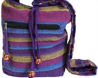 May include: A colorful shoulder bag with horizontal stripes in shades of purple, blue, and gold. The bag has a zippered pocket, a drawstring closure, and a long strap. Decorative wooden beads adorn the drawstring ends.