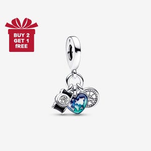 May include: A silver charm with travel-themed pendants. The charm features a camera with a clear gem, a heart-shaped world map, and a compass. The image also includes a red gift box with the text "BUY 2 GET 1 FREE".