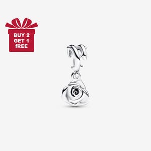 Puede incluir: Un charm de plata con un colgante de rosa. El charm tiene un lazo en la parte superior y una rosa detallada en la parte inferior. Una caja de regalo roja con el texto "BUY 2 GET 1 FREE" está en la esquina superior izquierda.