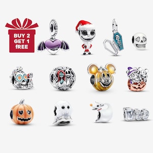 Puede incluir: Una colección de abalorios de plata con varios diseños, incluyendo un corazón púrpura con alas, una figura de Jack Skellington, un ataúd, una calavera, una calavera del Día de Muertos, un charm de Pesadilla antes de Navidad, una calabaza de Mickey Mouse, una calabaza, un fantasma, Zero y un charm "BOO".