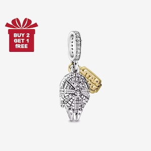 May include: A silver charm featuring the Millennium Falcon spaceship design, with a gold-colored Star Wars logo tag. The charm has a silver loop with clear stones. A red gift box with the text "BUY 2 GET 1 FREE" is in the upper left corner.