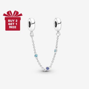 Può includere: Una catena di sicurezza per bracciale in argento con due elementi terminali rotondi e una catena con tre pietre blu. Il testo "BUY 2 GET 1 FREE" è su una confezione regalo rossa.