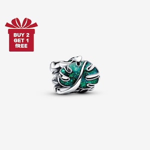 May include: A silver charm with a green, leaf-shaped design. The charm has a detailed, textured surface and is set against a white background. The image also includes a red gift box with the text "BUY 2 GET 1 FREE".