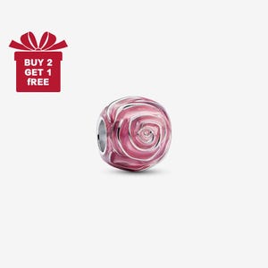 Puede incluir: Un charm de cuentas de vidrio rosa y blanco con un diseño de rosa. El charm tiene un núcleo de metal plateado y es de forma redonda. La imagen también incluye una caja de regalo roja con el texto "BUY 2 GET 1 FREE".
