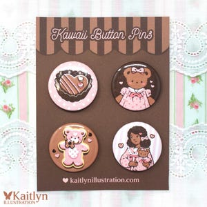 Op de afbeelding: Een set van vier Kawaii Button Pins op een bruine kaart. De pins tonen schattige illustraties van een hartvormig dessert, teddyberen en een meisje met een teddybeer. De tekst "Kawaii Button Pins" en "kaitlynillustration.com" zijn zichtbaar.