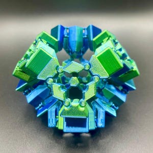 May include: A 3D printed geometric sculpture with a blue and green colour gradient. The sculpture is made up of many small, interconnected pieces.