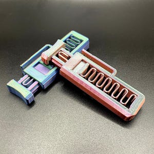 May include: A 3D printed iridescent blue and red toy gun with a textured surface.