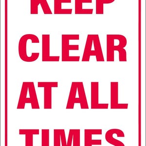May include: A rectangular sign with a white background and a red border. Bold red text reads "KEEP CLEAR AT ALL TIMES". The sign is designed for clear visibility and safety messaging.