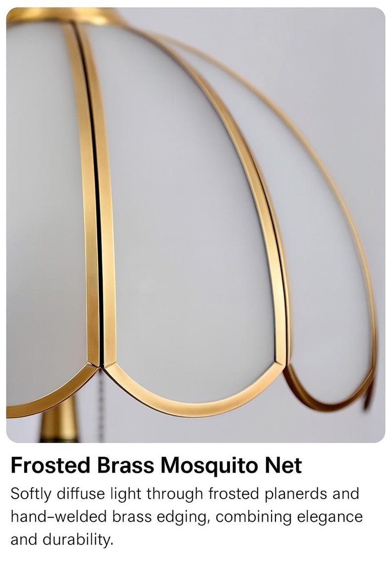 Pu&ograve; includere: Primo piano di una lampada a zanzariera in ottone smerigliato. La lampada presenta un paralume bianco a forma di petalo con bordi in ottone dorato. Il design combina eleganza e durata, diffondendo la luce delicatamente.